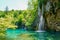 Sunny summer day. A transparent shallow lake reflects the forest. Plitvice Lakes Park in Croatia, Central Europe. Many picturesque