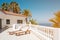 Sunny terrace with sun beds of ocean view house with palm trees anb blue sky copy space