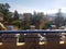 Sunny terrace with a view of a castle, trees, and hills