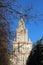 Sunny view of Moscow State University main building with reflections in windows through autumn tree branches