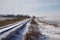 Sunny view of a rural railroad track dusted with fresh snow after a snow storm