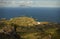 Sunny view of Sao Miguel, Azores island. Background of green fields, cosy village, blue ocean water and neighbour island