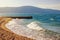 Sunny winter day. Waves on deserted sandy beach. Beautiful Mediterranean landscape. Montenegro, Bay of Kotor