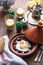 Sunnyside Eggs cooked in a Tajine dish with beef, Moroccan breakfast with juice and mint tea