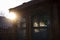 Sunrays illuminate a frost pattern on a window of a tool shed on a winter morning