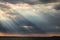 Sunrays at near sunset, with dark clouds in the background, above Trasimeno lake Umbria, Italy