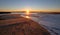 Sunrays and reeds at sunrise reflecting in the Santa Clara river / tidal inlet at McGrath State Park in Ventura California USA