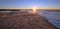 Sunrays and reeds at sunrise reflecting in the Santa Clara river / tidal inlet at McGrath State Park in Ventura California USA