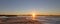 Sunrays and reeds at sunrise reflecting in the Santa Clara river / tidal inlet at McGrath State Park in Ventura California USA