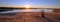 Sunrays and reeds at sunrise reflecting in the Santa Clara river / tidal inlet at McGrath State Park in Ventura California USA