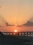 Sunrice over the pier-Reflections off clouds