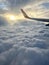 Sunrise above clouds from a plane window. Beautiful blue sky and fluffy clouds view from the airplane.