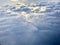 Sunrise above clouds from a plane window. Beautiful blue sky and fluffy clouds view from the airplane.