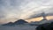 Sunrise above Lake Batur Covered with Clouds and Mount Agung Erupting Smoke - Seen from Top of Mount Batur in Bali, Indonesia.