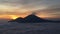 Sunrise above Lake Batur Covered with Clouds and Mount Agung Erupting Smoke - Seen from Top of Mount Batur in Bali, Indonesia.