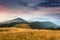 Sunrise above peaks of smoky mountain with the view of forest in the foreground.