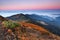 Sunrise. Autumn morning. Fall scene. Landscape with high mountains. Panoramic view. Natural landscape. The lawn with orange grass