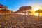 The sunrise behind the sunshade, Malagueta beach, Malaga, Spain