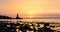 Sunrise on the Bulgarian Black Sea coast in Athopol with the harbor lighthouse and rocky shore