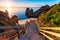 Sunrise at Camilo beach in Lagos, Algarve, Portugal. Wooden footbridge to the beach Praia do Camilo, Portugal. Picturesque view of