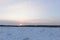 Sunrise in a cloudy winter sky over a forest swamp