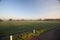 Sunrise with colored aircraft trails, fog on the meadows and at River Hollandsche IJssel