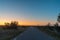 Sunrise at a country road in a plane barren landscape