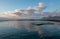 Sunrise cumulus cloud reflections over Dale Brook Tide Pool in Cape Town South Africa SA