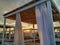 Sunrise in the early morning on the beach with closeup of white curtains on romantic wooden sunshades house parasol beach