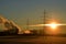 Sunrise with electricity pylons and chimneys of an industry