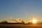 Sunrise with electricity pylons and chimneys of an industry