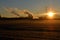 Sunrise with electricity pylons and chimneys of an industry