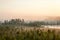 Sunrise in evergreen forest with bog, haze over water and land, northern Karelia, Russia