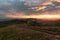 Sunrise on farmland hill with colorful sky and tourists camping on vacation in national park