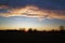 Sunrise in field with a cloudy sky