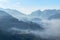 Sunrise on high angle view with white fog in early morning over rainforest mountain in thailand