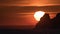 Sunrise with huge sun and lake sea and rock hill mountain time lapse. Red and black dawn. Dramatic