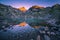 Sunrise Illuminating Mountain Peaks and Reflecting in Crystal Clear Altitude Lake