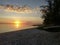 The sunrise on the lagoon with trees, sand and a water mirror. In Praia Seca, Rio de Janeiro, Brazil.