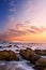 Sunrise landscape of ocean with waves clouds and rocks