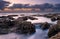 Sunrise landscape of ocean with waves clouds and rocks