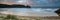 Sunrise landscape panorama Three Cliffs Bay in Wales with dramatic sky