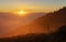 Sunrise landscape, silhouette trees and mountain range with yellow sunlight in the morning sunrise