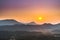 Sunrise in Laos Asia foggy and hazy morning with low sun purple and orange clear skies and mountain background