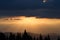 Sunrise in the mountains. Outlines of spruce tops and the sun`s rays make their way through clouds peaks. background. Coniferou