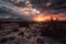 sunrise over the desert with clouds and sky in dramatic colors