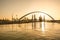 Sunrise over Dubai skyline behind a water canal.