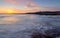 Sunrise over Dunstanburgh Castle on the coast of Northumberland, England, UK.