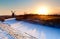 Sunrise over Dutch windmill and frozen canal