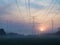 Sunrise over the fields and pylons